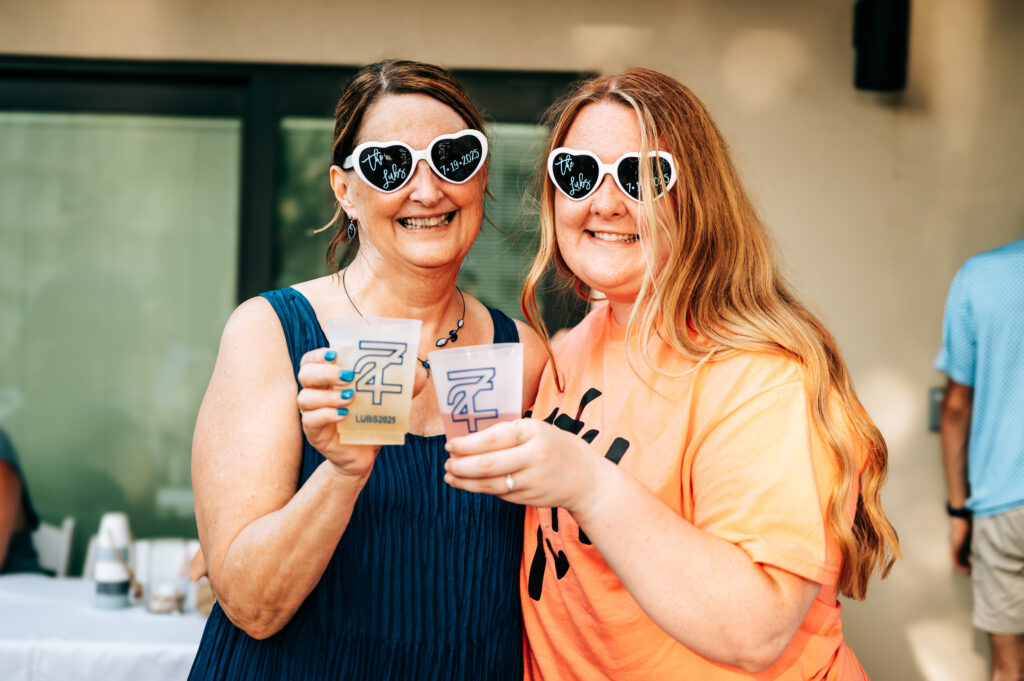 Wedding guests raising drinks and celebrating during the Lubbs Lake of the Ozarks wedding weekend