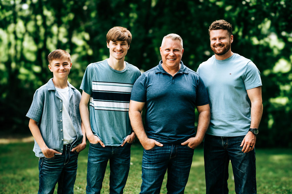 Adult siblings laughing together during family session with dad in Brunswick, MO