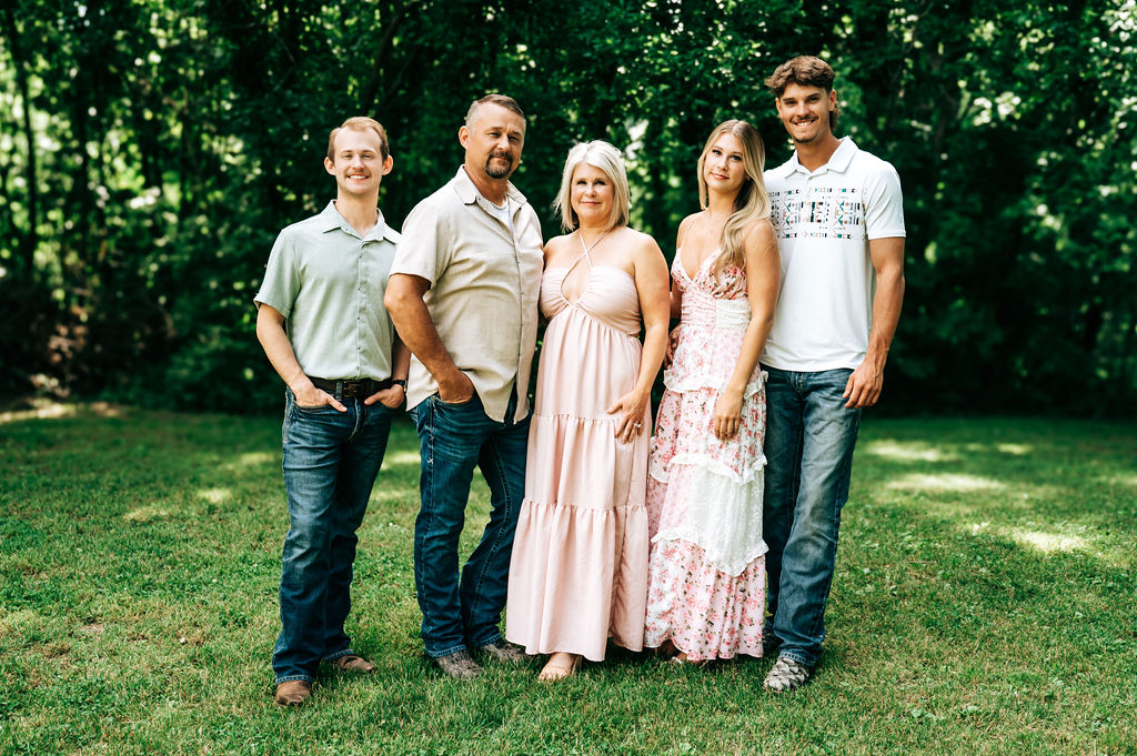 Family of four smiling together during extended family session in Brunswick, Missouri