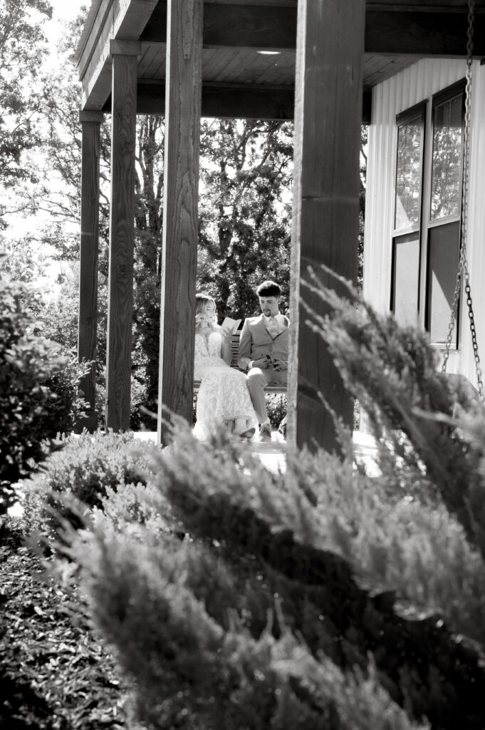 Ethan and Taylor sharing private wedding vows on the porch swing at Briarwood Hills Wedding and Event Venue