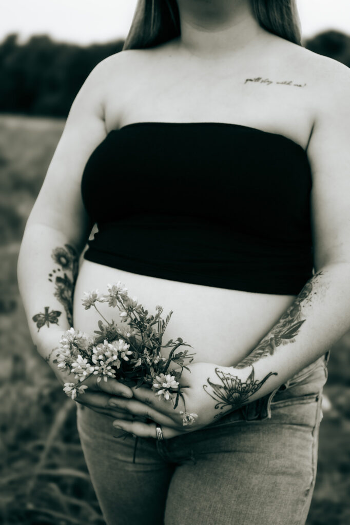 Pregnant mom posing in a field for maternity photos