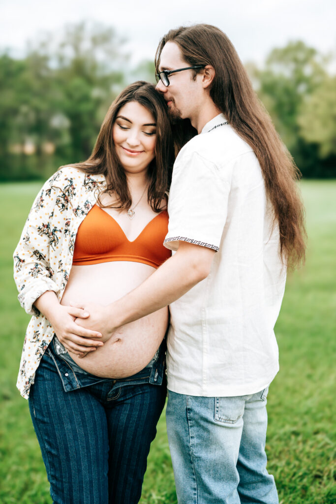 Dad holding mom’s baby bump during maternity session
