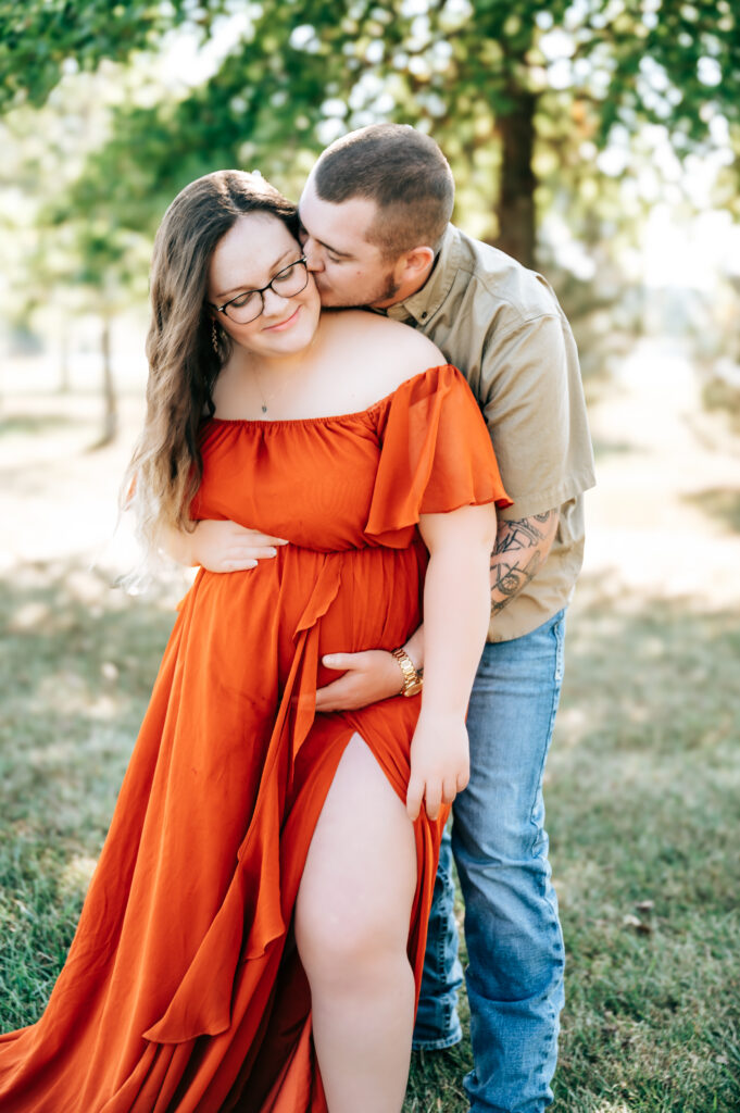 Expecting mother cradling belly during maternity photos