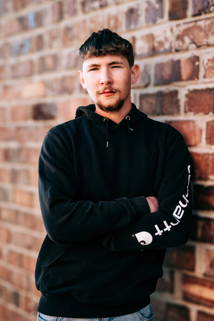 Missouri senior guy portrait featuring a Carhartt hoodie and relaxed posing