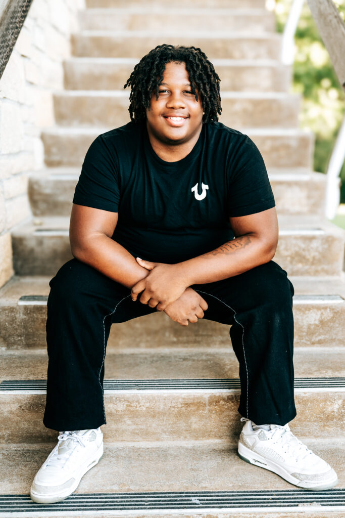 Macon senior football player posing on steps for senior portraits